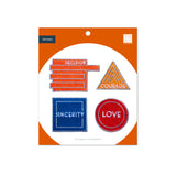 Set of patches with motivational phrases on a white and orange packaging