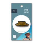 Pin with a design of Frank Lloyd Wright's hat on a blue and white card.